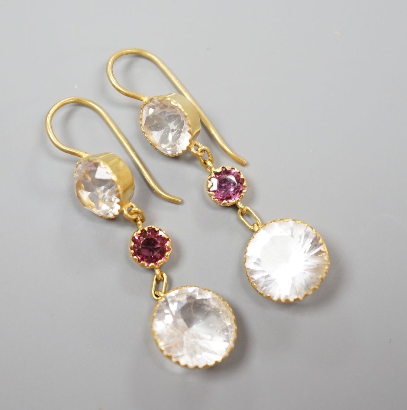A pair of yellow metal, rock crystal and garnet? set three stone drop earrings, overall 37mm, gross 3.1 grams.